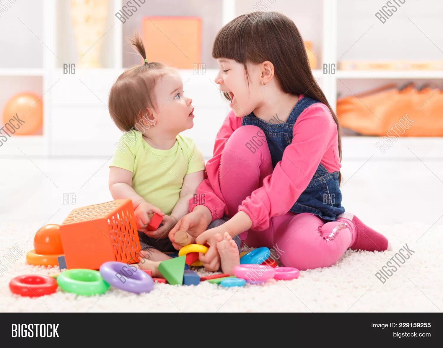 Сестра играет в игрушки. Ребенок отделяющий игрушки. Ребенок отделяющий игрушки рукой. Sister playing.