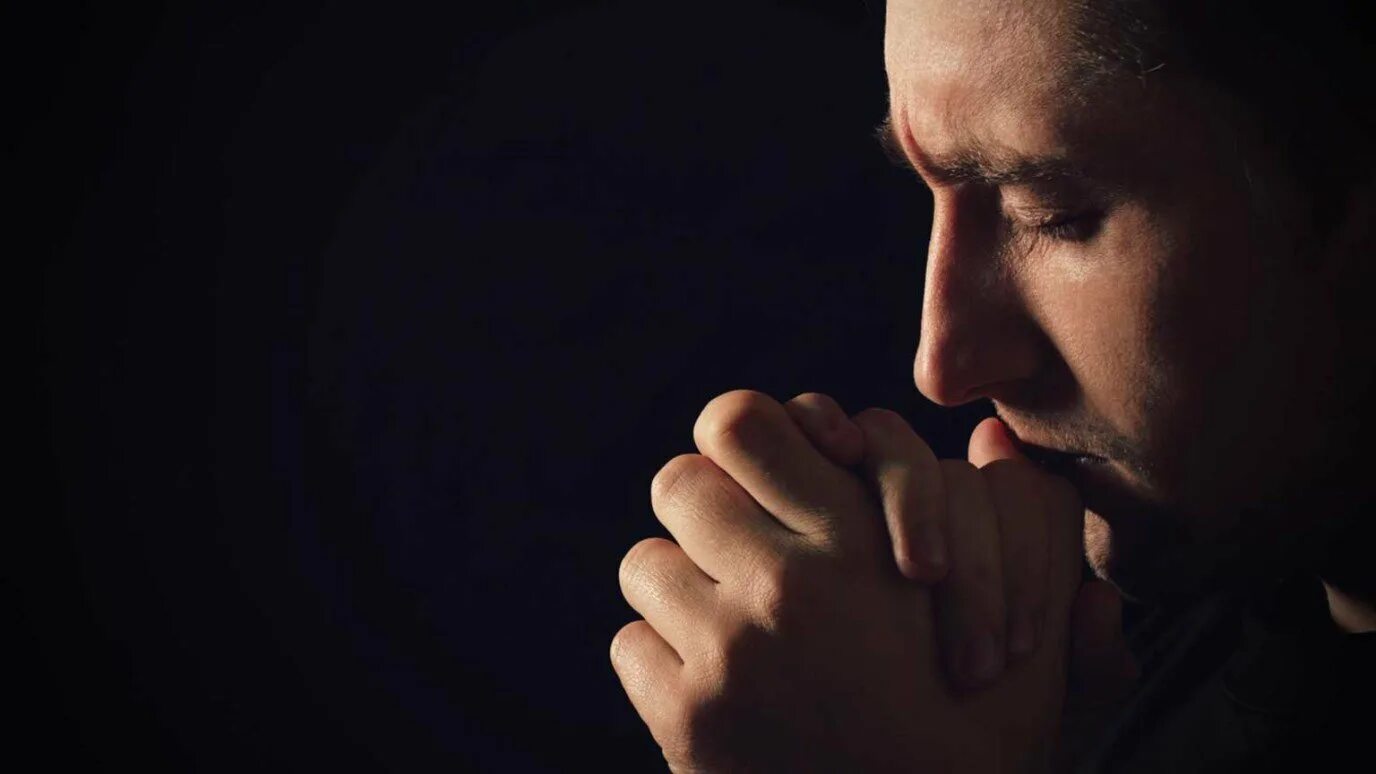 Боль взывает к людям. Человек молится. Мужик молится. Молитва мужчины. Молодой человек молится.
