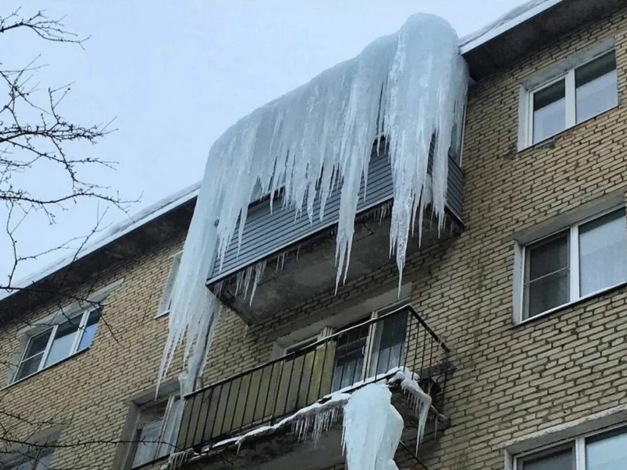 С крыш падает вода. Сосульки на доме. Сосульки на крыше. Сосульки на балконе. Сосульки на крышах домов.