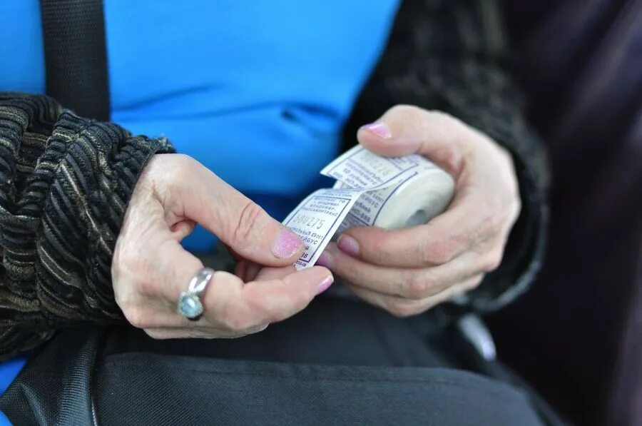 Проезд в транспорте подорожает. Кондуктор с билетами. плата за проезд в автобусе. проезд дорожает. билет за проезд в автобусе.