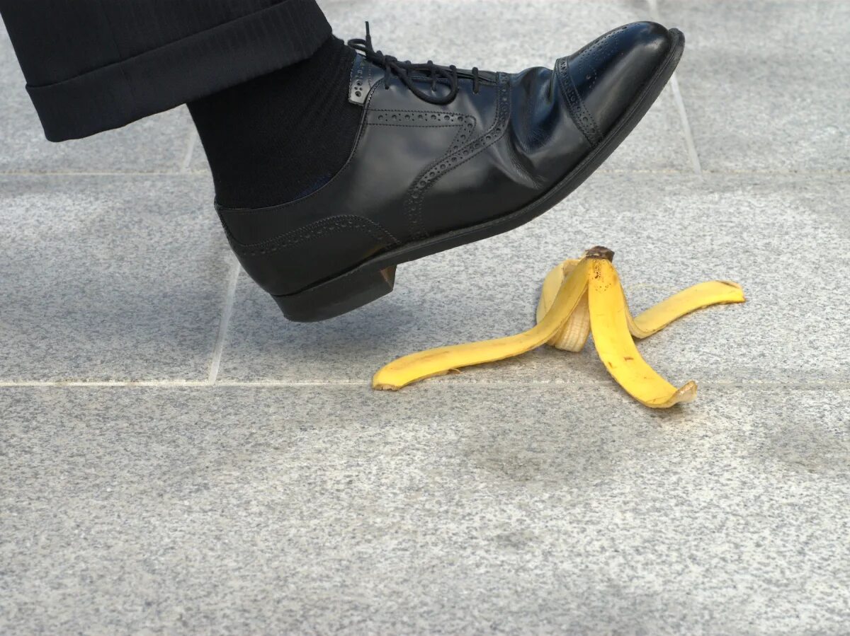 Человек кожура. Наступил на банан. Человек наступает на банановую кожуру. Поскользнуться на шкурке от банана. Нога поскальзывается на банане.