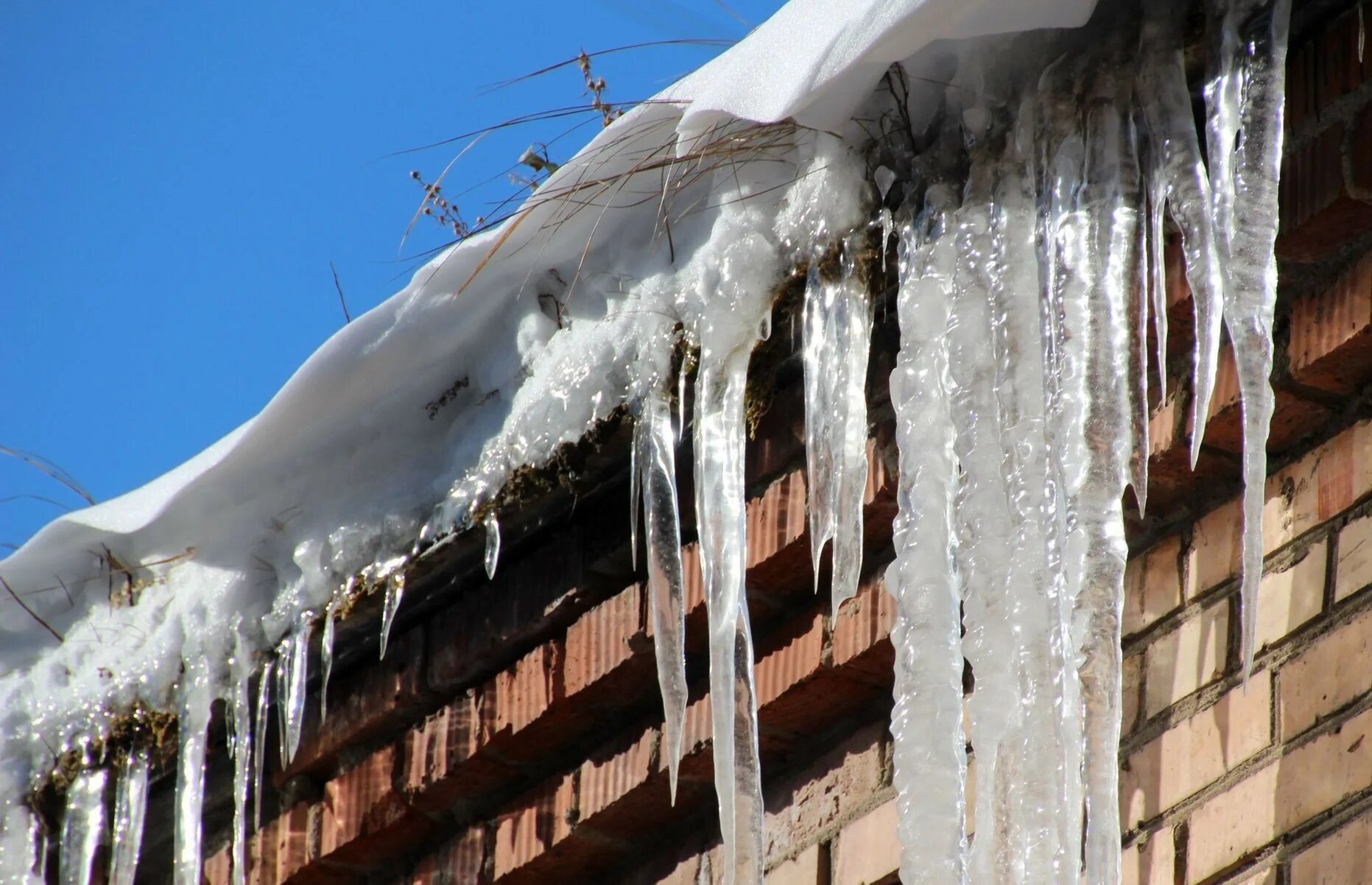 лед под крышей. под ледяной крышей. падающие сосульки. сосульки на крыше. большие сосульки.