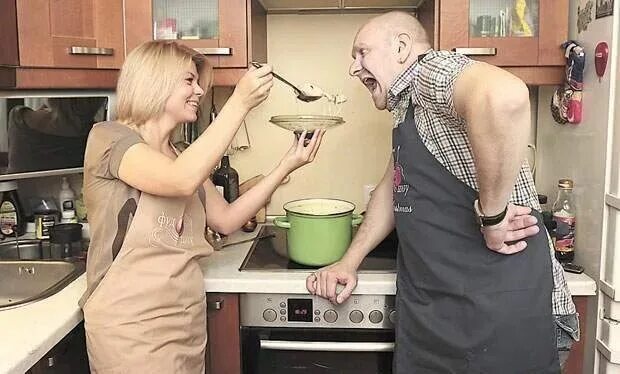 Пока жена готовит муж. Муж женой на кухне веселая. Муж и жена на кухне смешные. Супруга на кухне. Муж и жена едят.