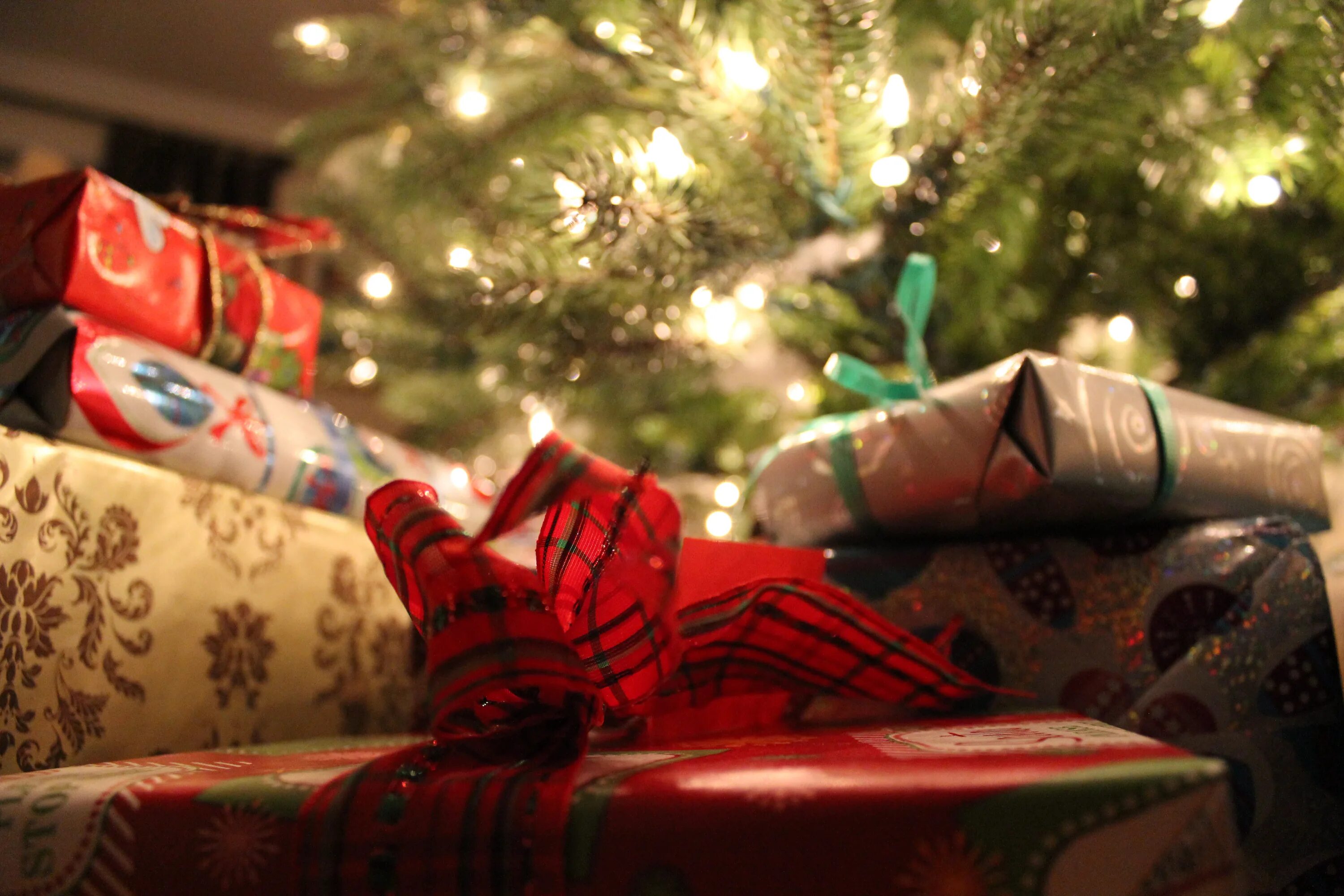 Работает ли в новый год. Подарки под ёлкой. Мешок под елкой. Мешок новогодний под елкой. Подарки под елкой США.