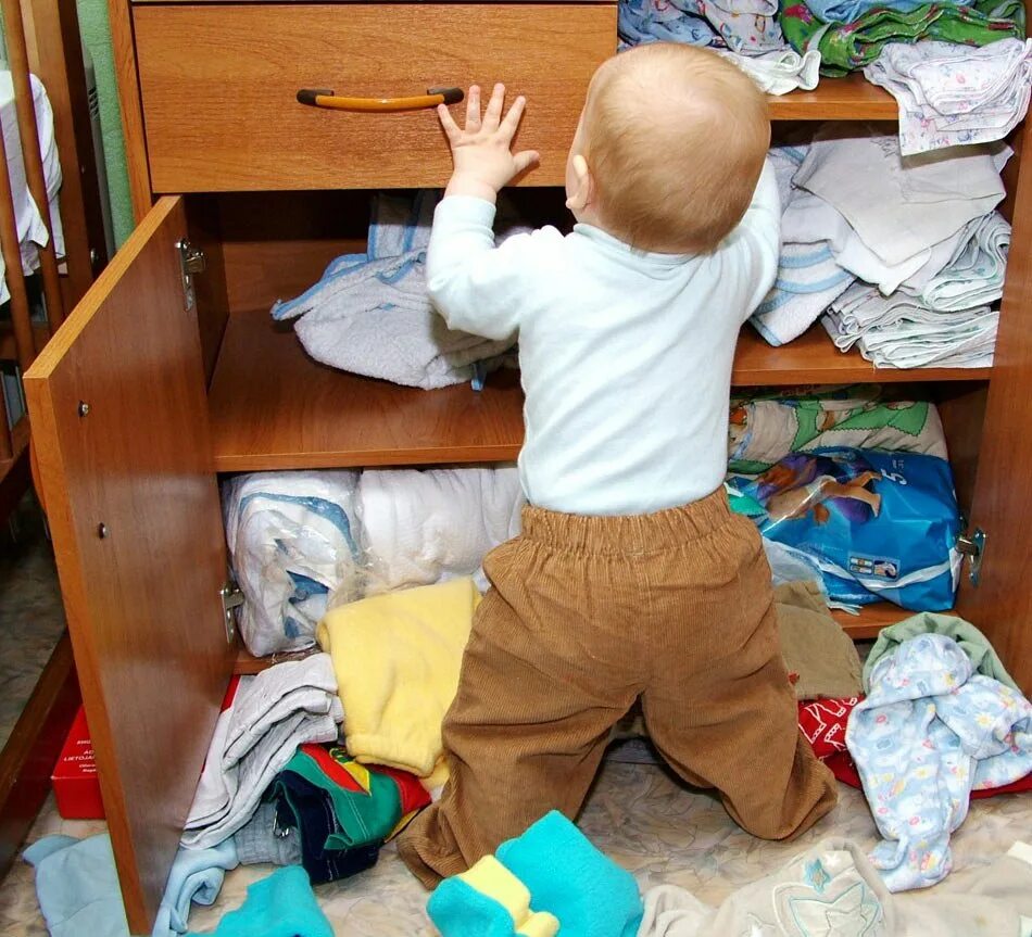 На 2 полки в шкафу дети. Беспорядок в шкафу с одеждой. Ребенок убирает игрушки. Разбросанные детские вещи. Шкаф для малыша.