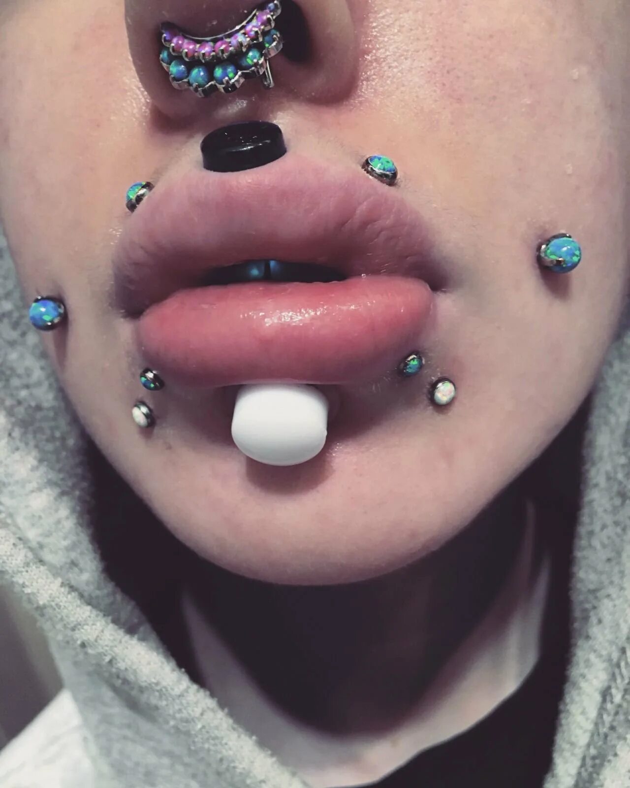 Пирсинг на шее микродермал. Как делается прокол. Лабрет нижней губы кольцо. Вертикальный лабрет пирсинг нижней губы. Лабрет пирсинг ламберт.