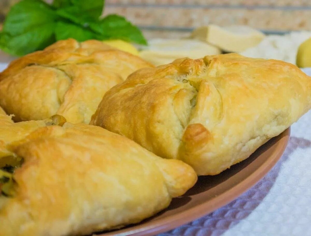 Пирожки из готового мяса. Пирожки с картошкой на слоеном тесте. слойки с капустой. пирожок с курицей и сыром. слоеные пирожки с капустой.