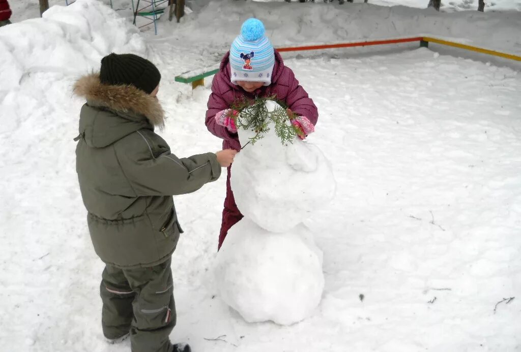 Лепить снеговика зимой. Дети лепят снеговика. Снеговик во дворе. Снеговик с детьми во дворе. Дети лепят из снега.