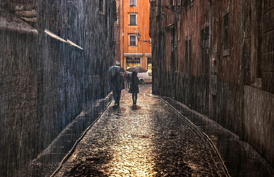 Дождь в большом городе. Город под дождем. Улица под дождем. Пасмурная улица. Человек в подворотне.