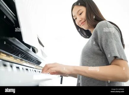 Portrait Asian woman playing playing piano Stock Photo. 