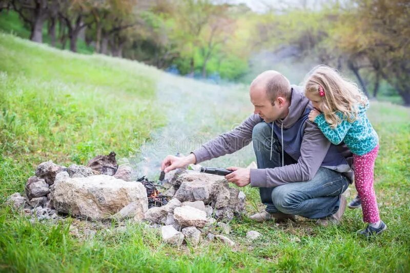 Папа и дочка разводят костер. Camping with dad