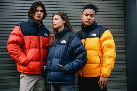 Двое парней и девушка в куртках The North Face.