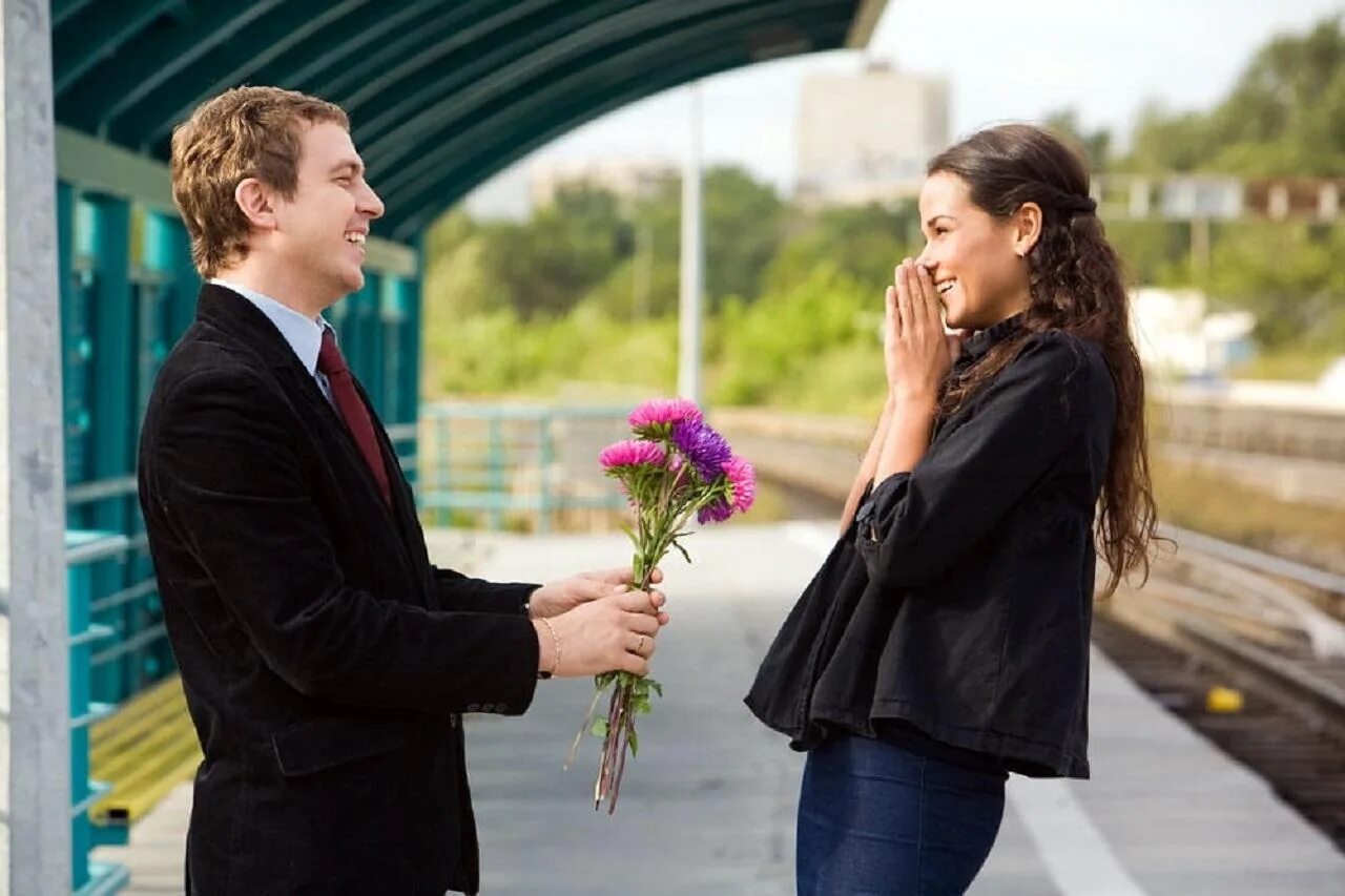 Date woman. Встреча мужчины и женщины. Девушке дарят цветы. Мужчина и женщина на свидании. Парень знакомится с девушкой.