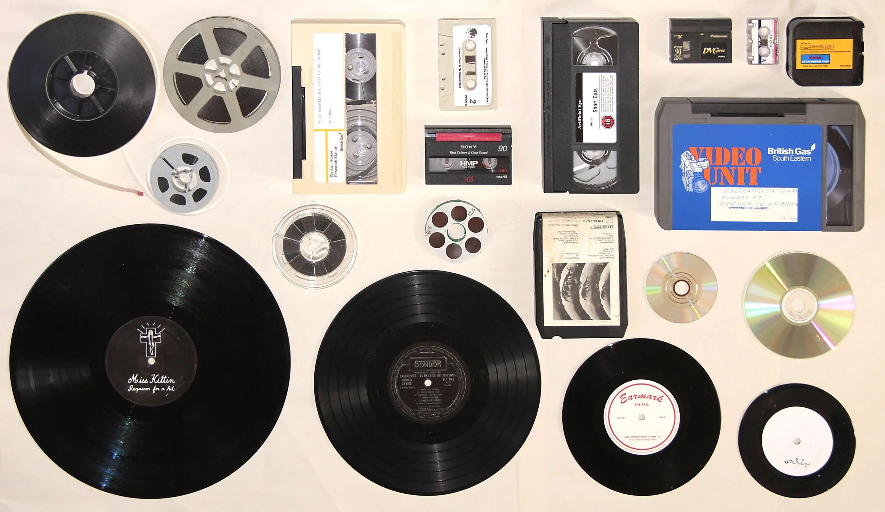 компакт-кассеты и диск. грампластинки компакт-кассеты бобины. Tapes collected. девушка в студии звукозаписи. аппаратура для записи треков.