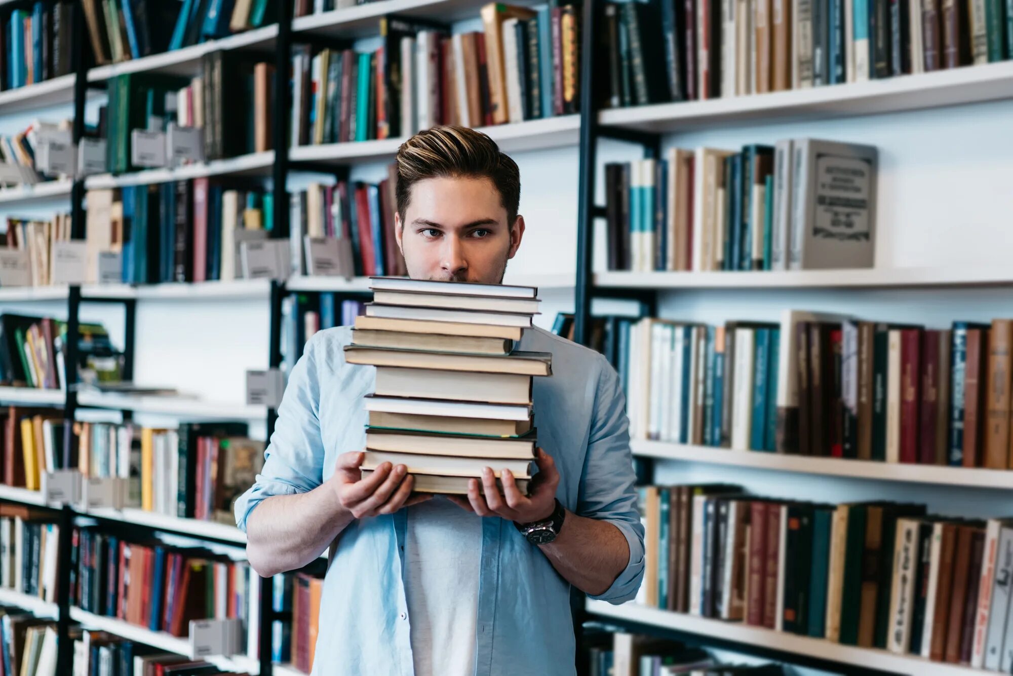 Students many books. Люди в библиотеке. Книга библиотека. Мужчина и много книг. Парень в библиотеке.