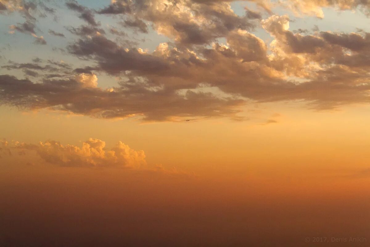 статуя христа в православии. бронза небеса. небо закат. облака в бронзе скульптура. огненный закат.