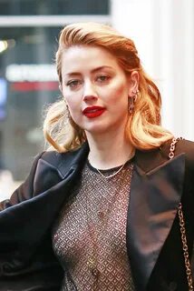 Amber Heard showing her shapely breasts in a see-through top.