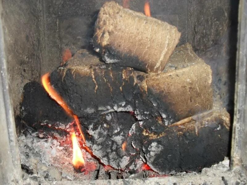 Брикеты из опилок. Топить брикетами. Чем лучше топить брикетами или дровами. Горящие брикеты в печи. Как горят топливные брикеты в печке.