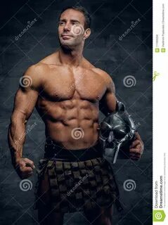 Photo about Athletic shirtless middle age male in a Rome soldier costume ho...