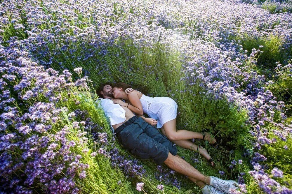 Влюбленные лежат на траве. Двое лежат на траве. Девушка среди цветов. Лежит на траве.
