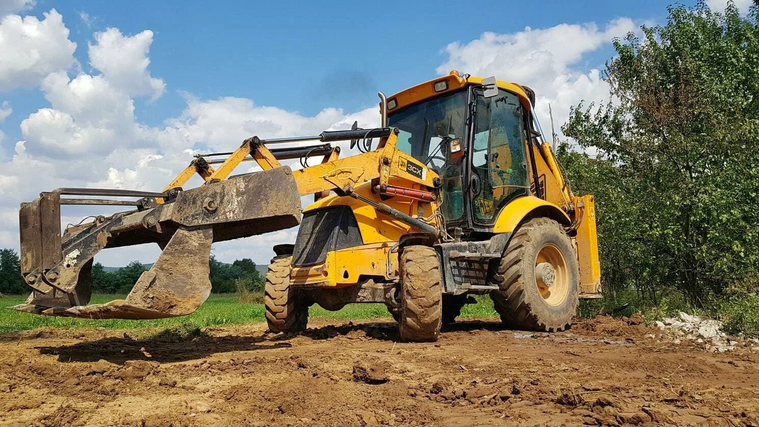 Clearing land. Длинная траншея экскаватор погрузчик.