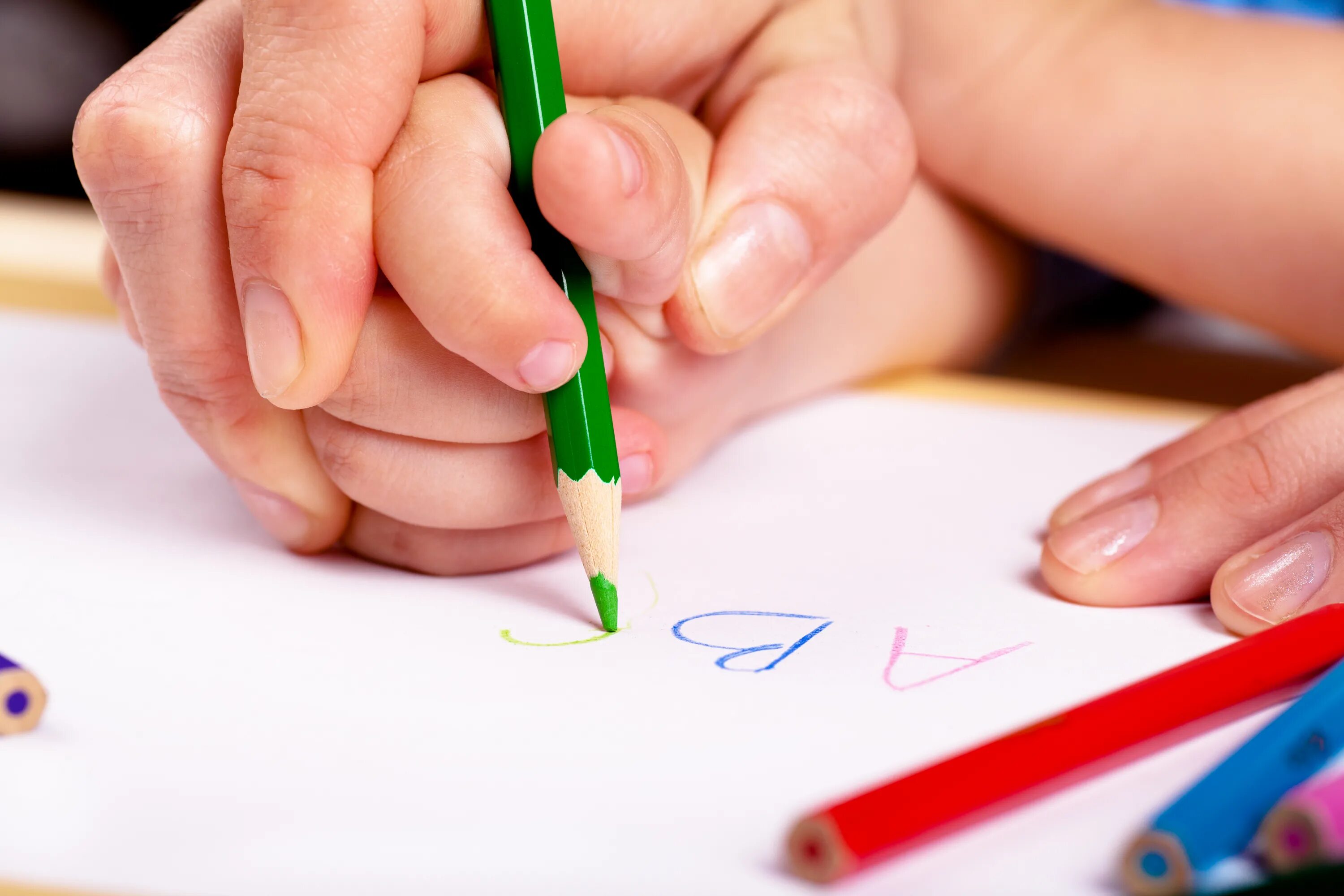 Картинки дети пишут буквы. Леворукий ребенок. Руки карандашом. Леворукий ребенок в школе. Рука ребенка с карандашом.