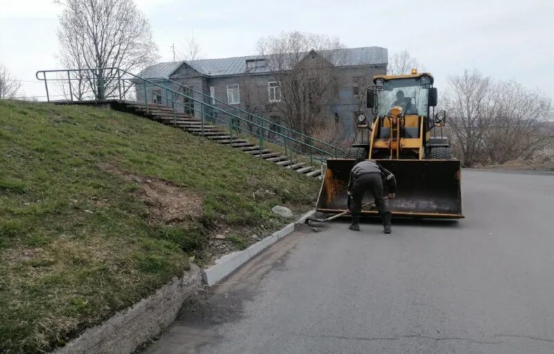 Уборка территорий от мусора и уборка снега. Ведутся работы по очистке территории. Уборка улиц. Весенняя расчистка снега. Дворник подметает.