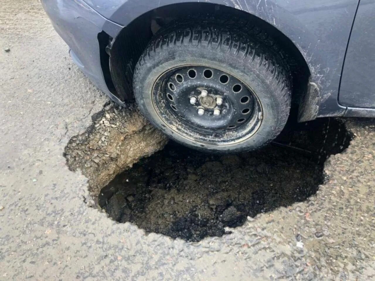 Колесо попало в яму на дороге. Колесо в яме.