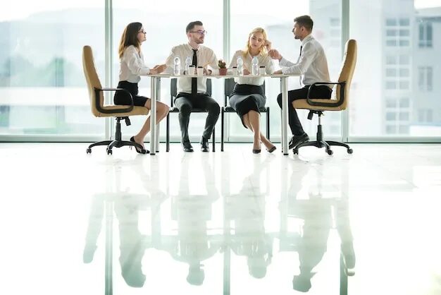 Занять место за столиком. Человек сидит за столом. Люди за столом со стороны. Люди за столом в офисе. Люди сидят за столом и обсуждают.
