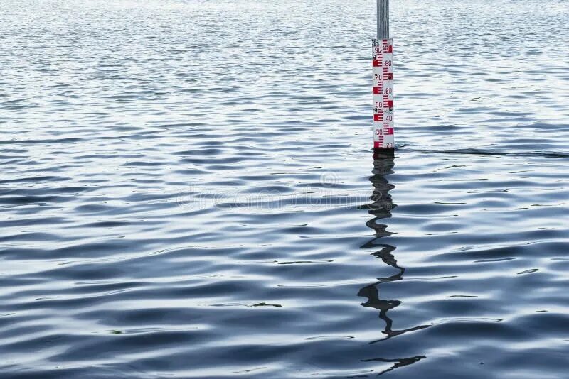 Замер уровня воды в реке. Рейка для замера уровня воды. Измерение уровня воды в реке. Столбики для измерения уровня воды в озере. Измерение уровня воды в водоеме.