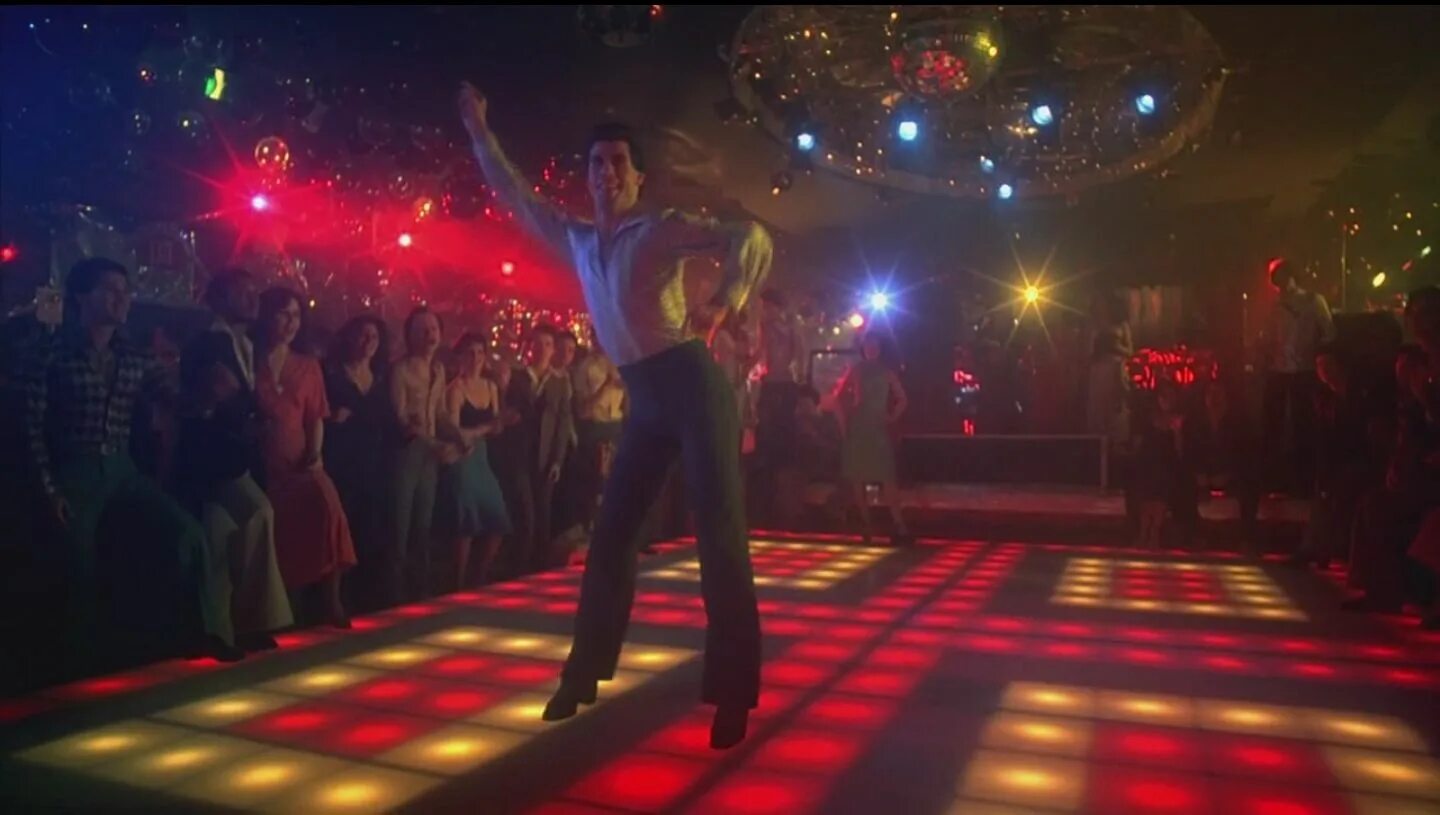 Песня на дискач выходит танцевать. John Travolta Saturday Night Fever. Джон Траволта Субботняя лихорадка. Saturday Night Fever Траволта. Дискотека субботнего вечера Джон Траволта.