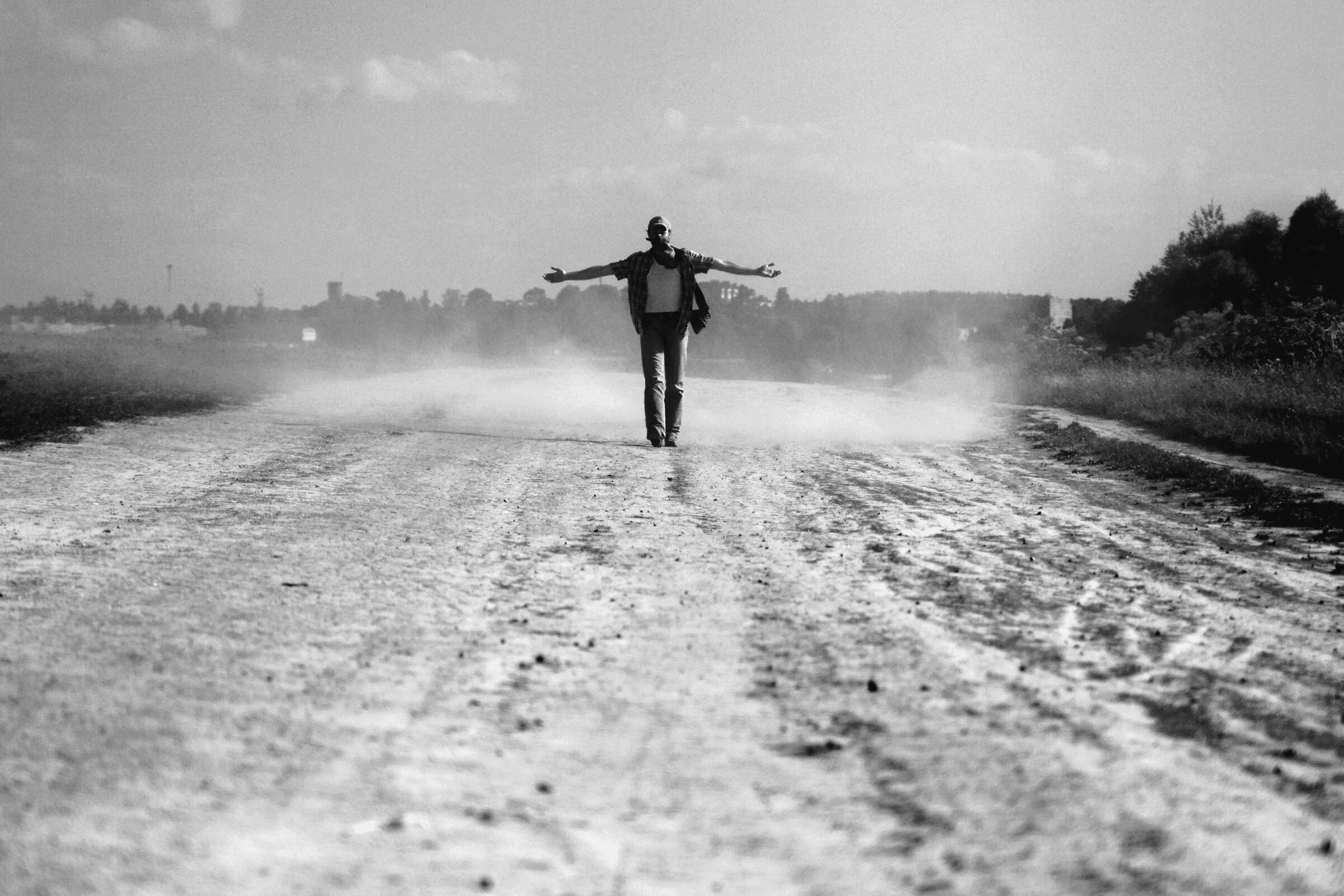Пыль дорог. Человек на пыльной дороге. Парень шагает по дороге. Фотосессия на пыльной дороге.