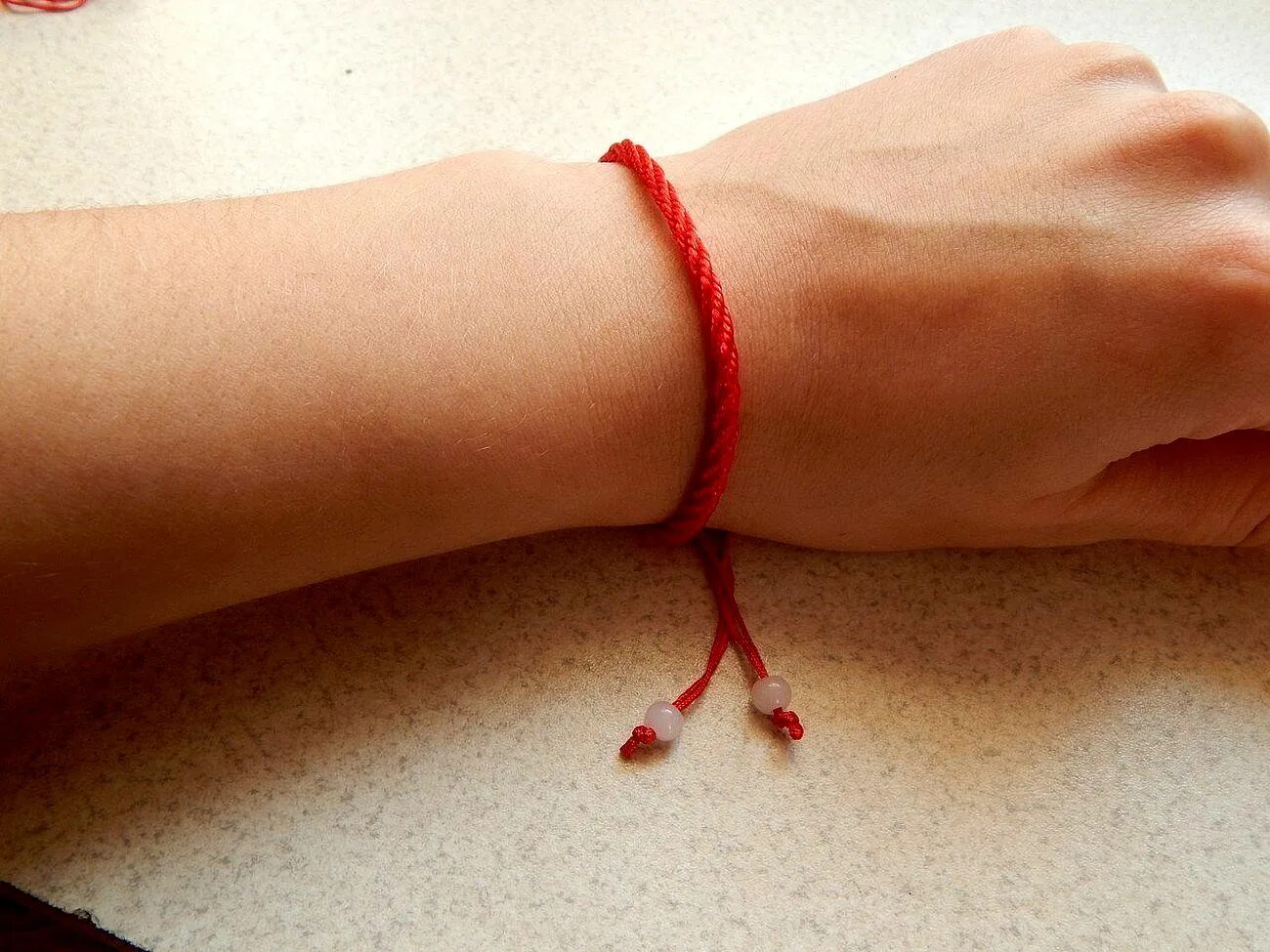 Красная нитка на руке. Красная ниточка на запястье. Красные браслеты на руку. Веревка на запястье