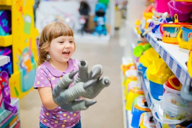 Choose toy. Маленькая девочка в магазине игрушек.