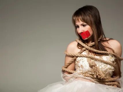 Woman in a dress bound and gagged. 
