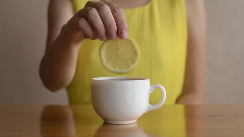 Выпить чаю лимоном. Пьет чай с лимоном. Чай с лимоном в кружке. Девушка и чай с лимоном. Девушка с лимонным чаем.
