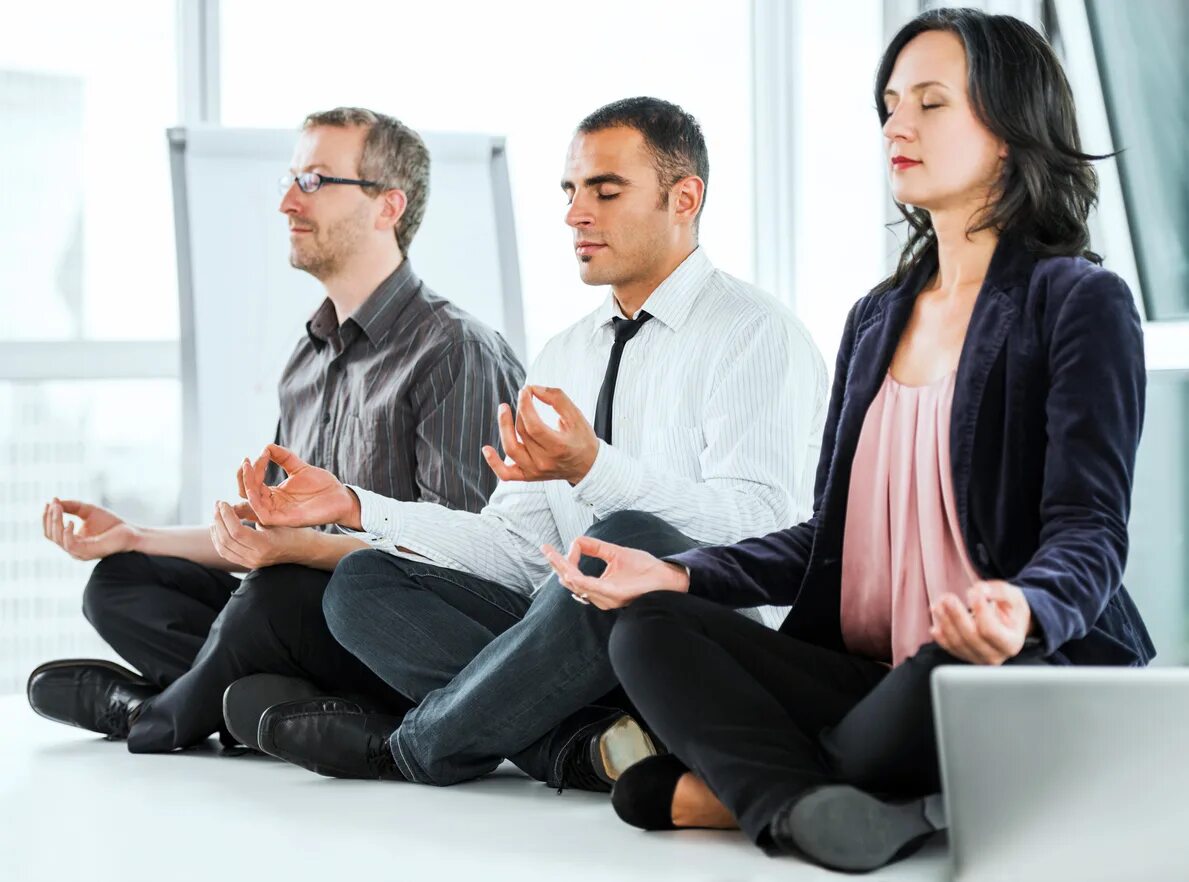 Атмосфера тренинг. Медитация в офисе. Мужской коллектив. Мужчина медитирует в офисе. Мужской коллектив на работе.