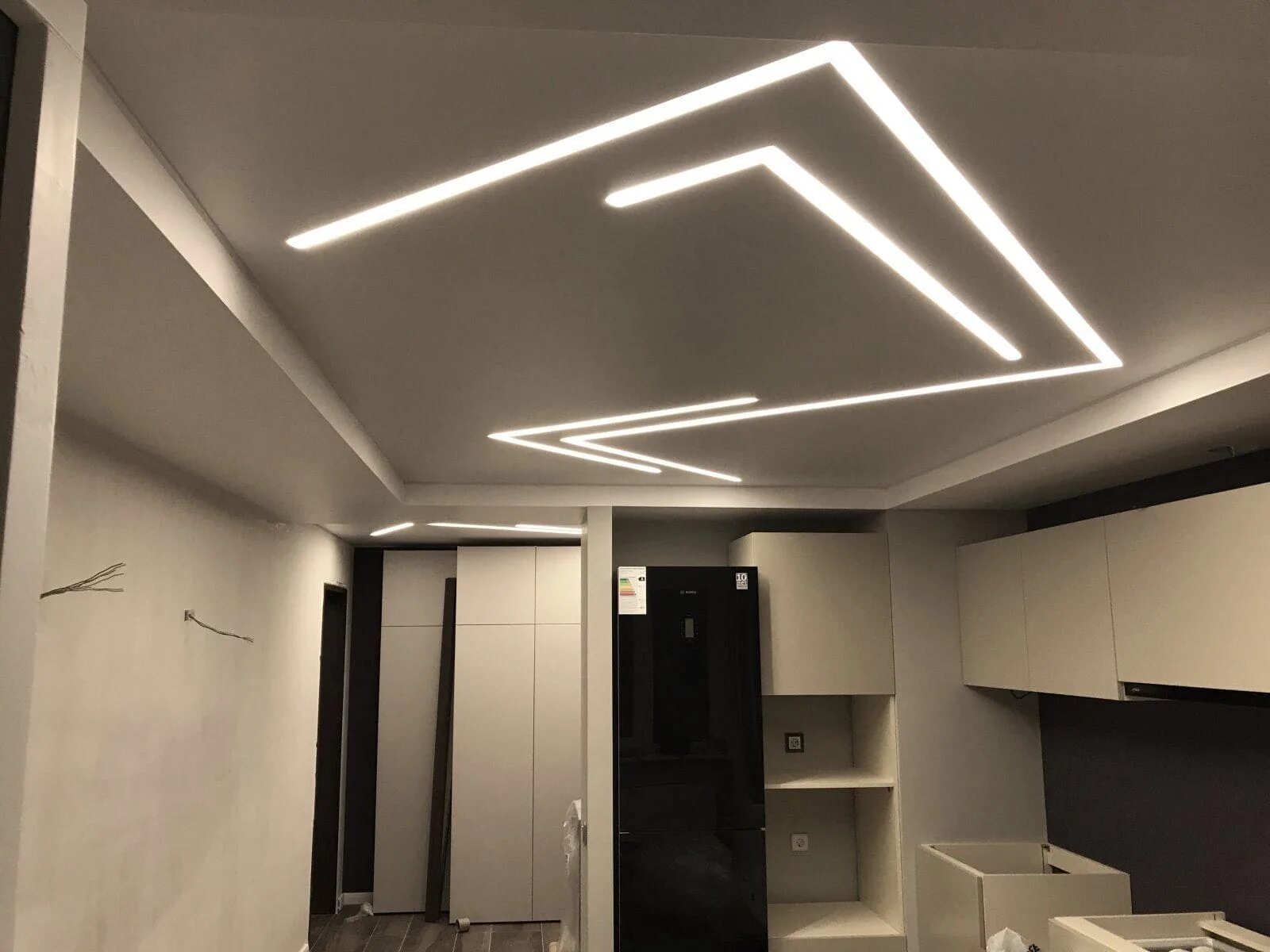 Световые линии в спальне на натяжном потолке. Потолок световые линии в гостиной. Потолок световые линии светлый. Линейные светильники светодиодные в интерьере. Освещение в гостиной с натяжным потолком.