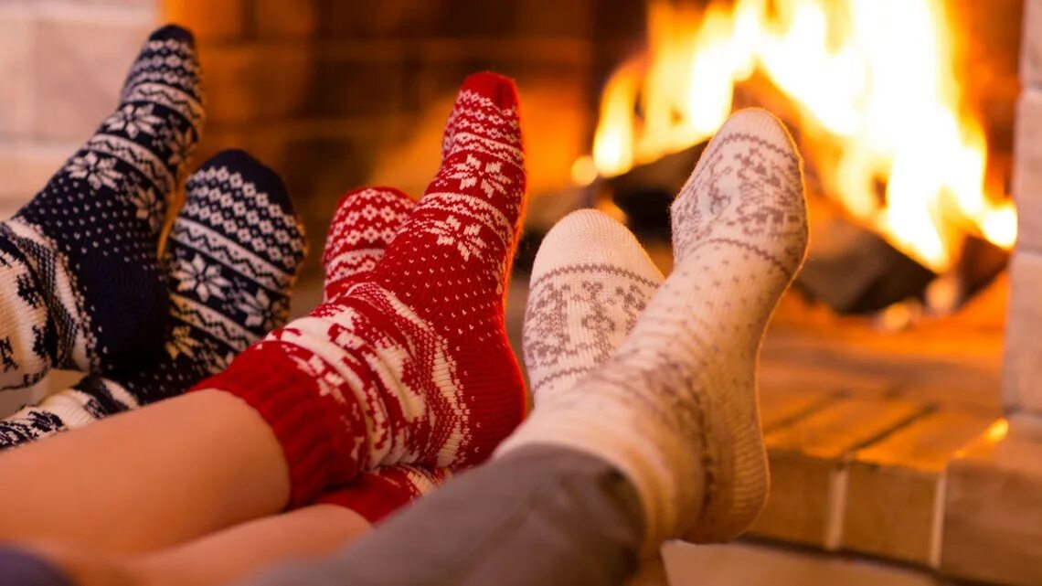 Пара теплых носков. Ноги в шерстяных носках. Ножки в новогодних носочках. Теплые носки. Семья носки у камина.