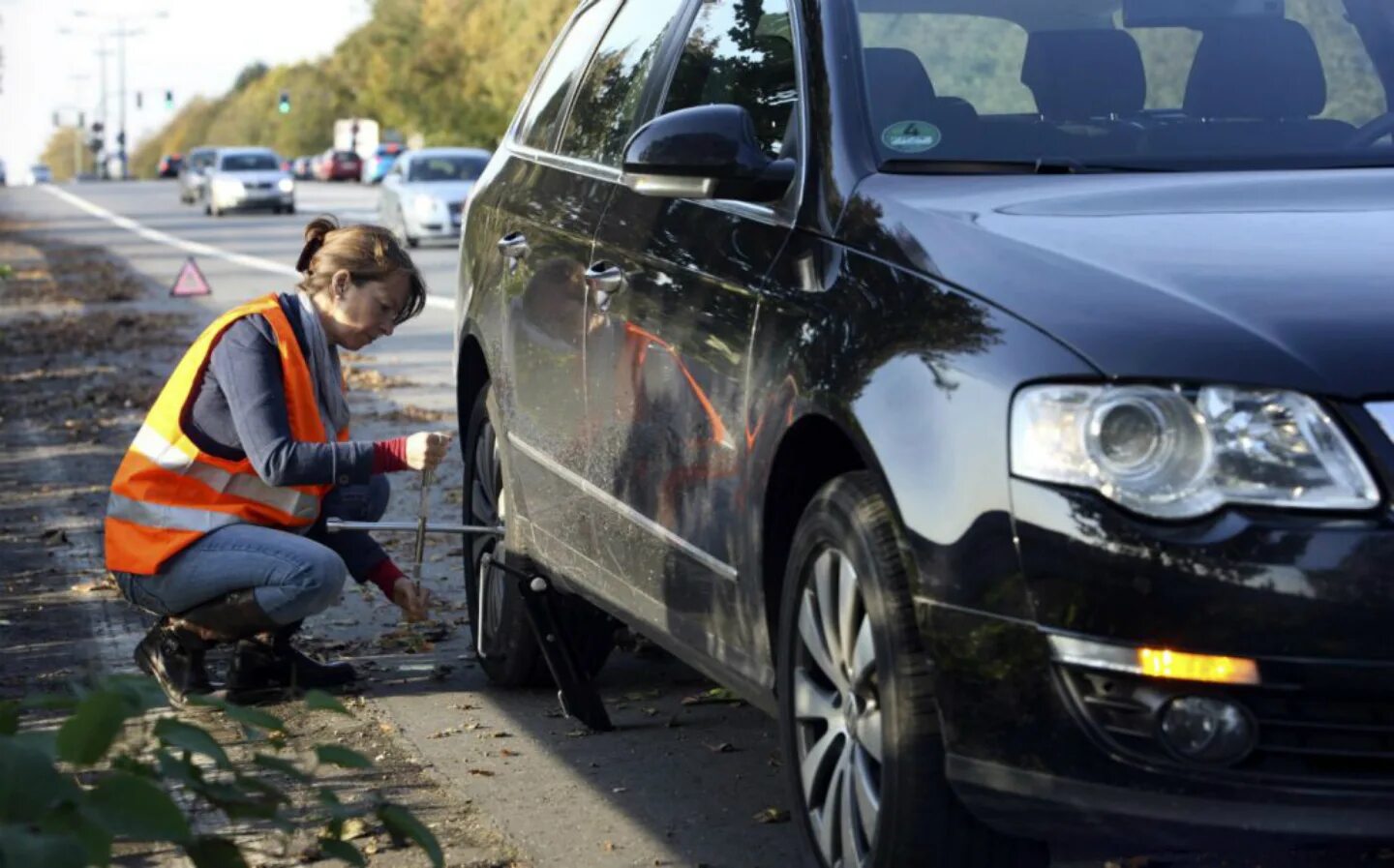 Вынужденная остановка. Водитель автомобиля в светоотражающей одежде. Световозвращающий жилет на дороге. Машина останавливается.