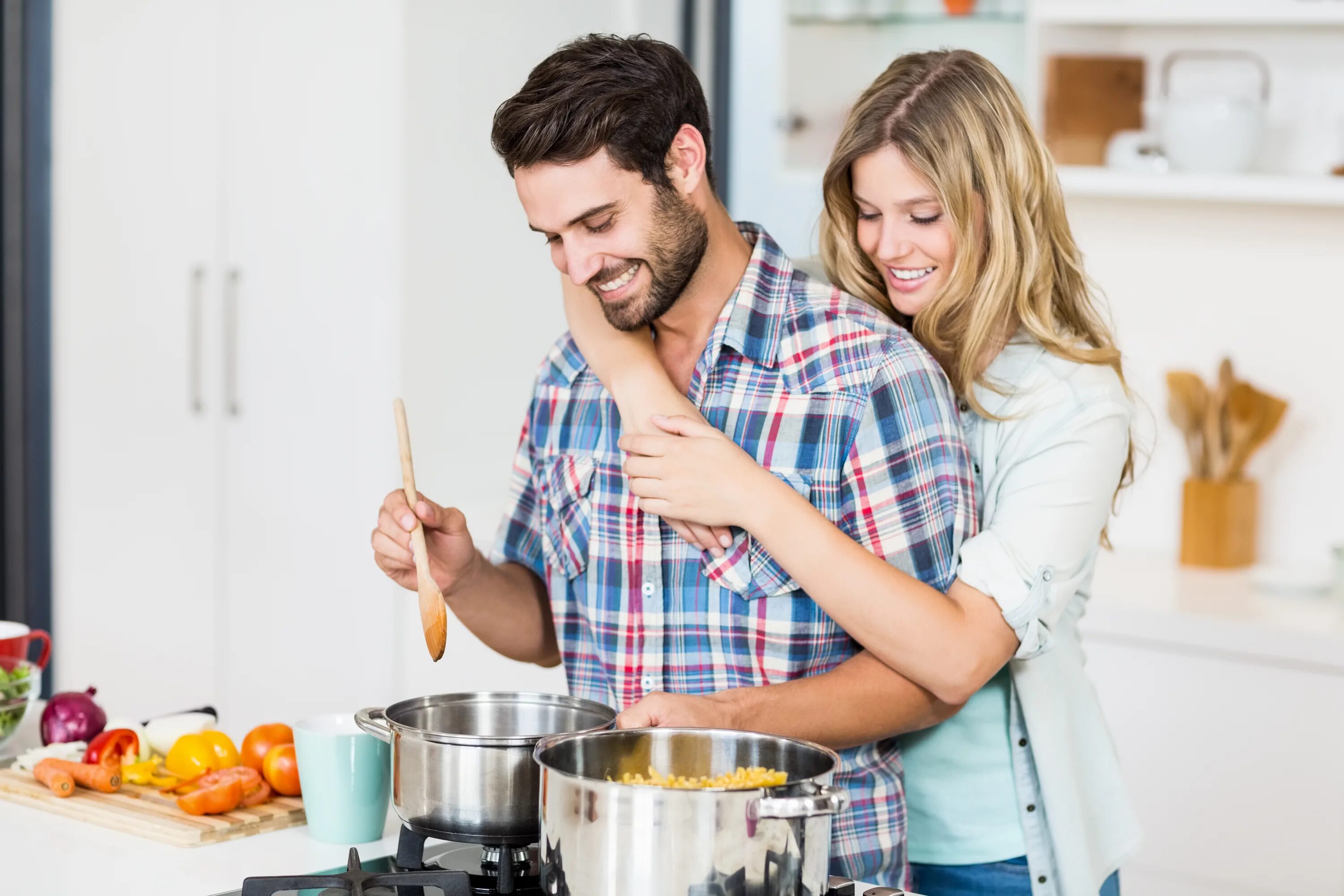 Готовим улыбаясь. Мужчина и женщина на кухне. Заботливый мужчина. Мужчина на кухне. Мужчина и женщина завтракают.