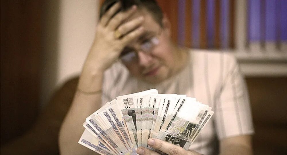 Большие и малые деньги. Маленькая зарплата. грустный человек с деньгами. низкая зарплата. деньги зарплата.