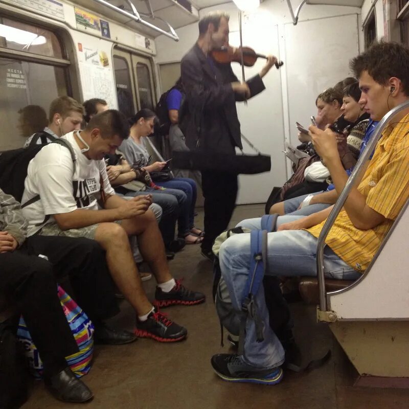 Проходить в метро по телефону. Люди в метро с телефонами. человек сидит в метро. люди со смартфонами в метро. люди с гаджетами в метро.
