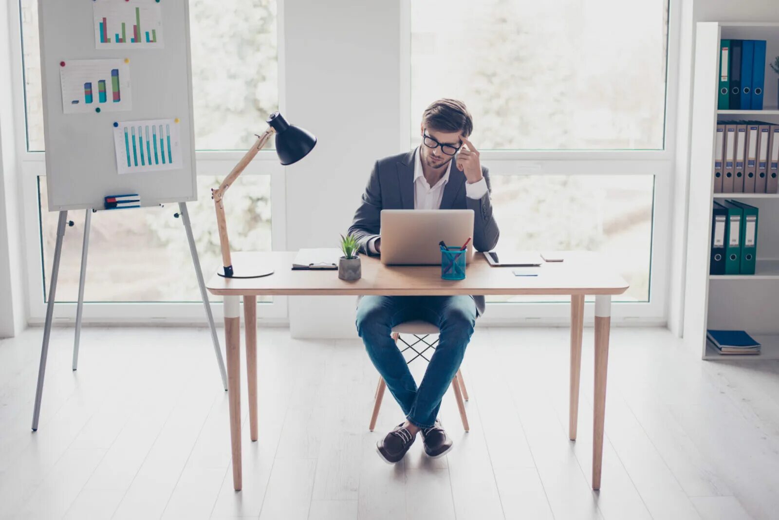 Behind the table. Sitting at desk. man at desk. at the desk. he is sitting sit at the desk.