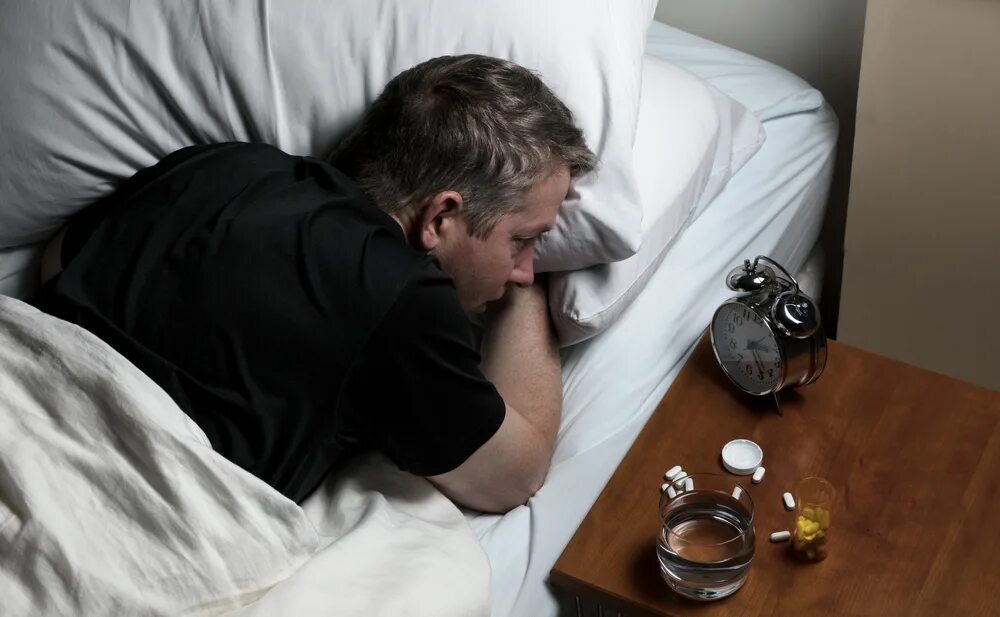 Бессонница у пьющих. Женщина пьет таблетки. Пьяная на кровати. Бессонница у пьющих. Алкоголь и сон.