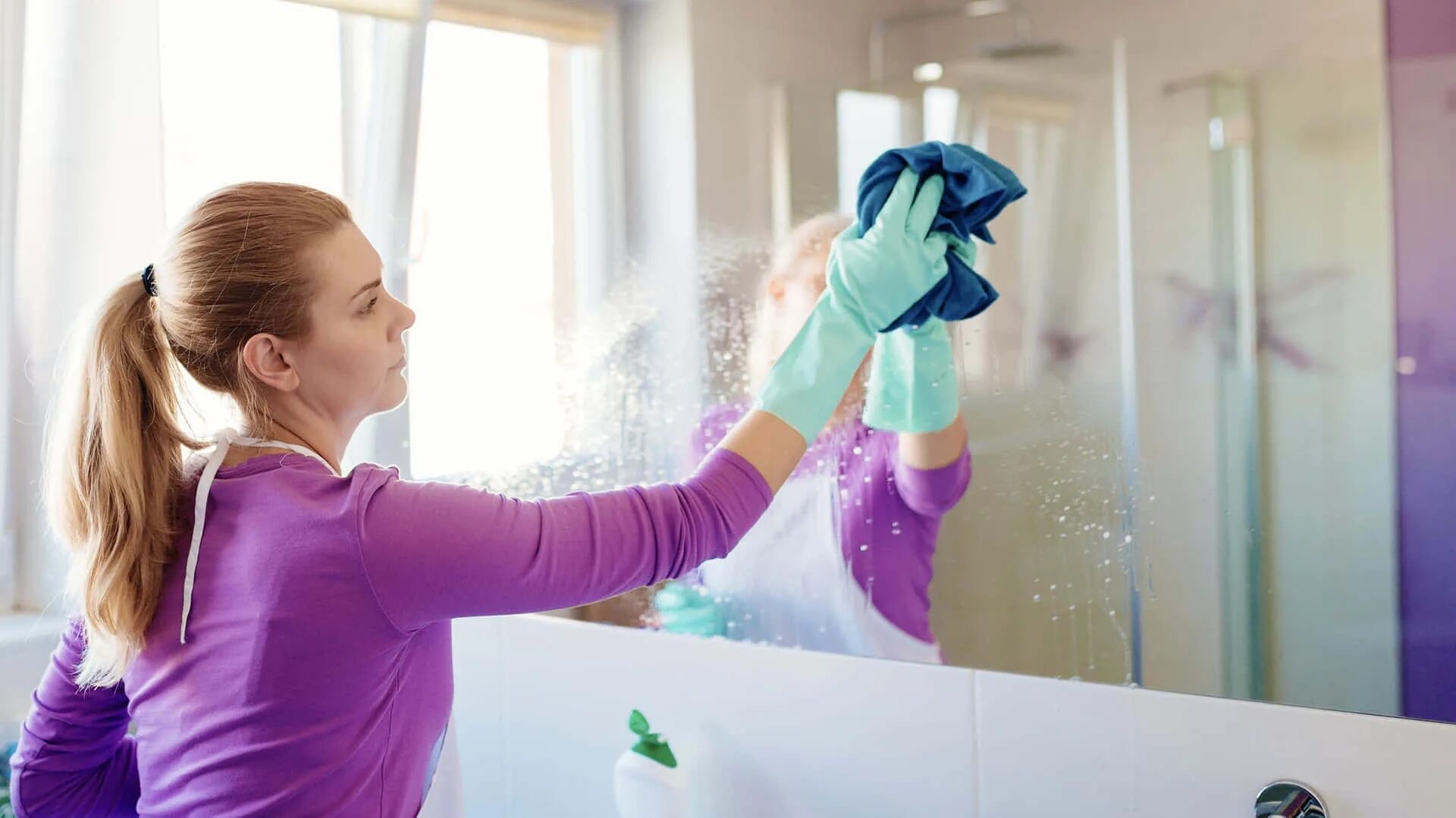 Woman cleaning. Уборка ванной комнаты. Мойка окон и зеркал. Мытье стекол. Протирает зеркало.