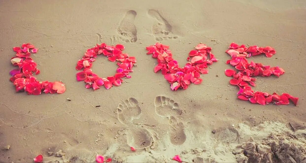 Любима без слов. Признание в любви на песке. Сердце из лепестков на песке. Романтичные надписи. Лепестки роз на песке.