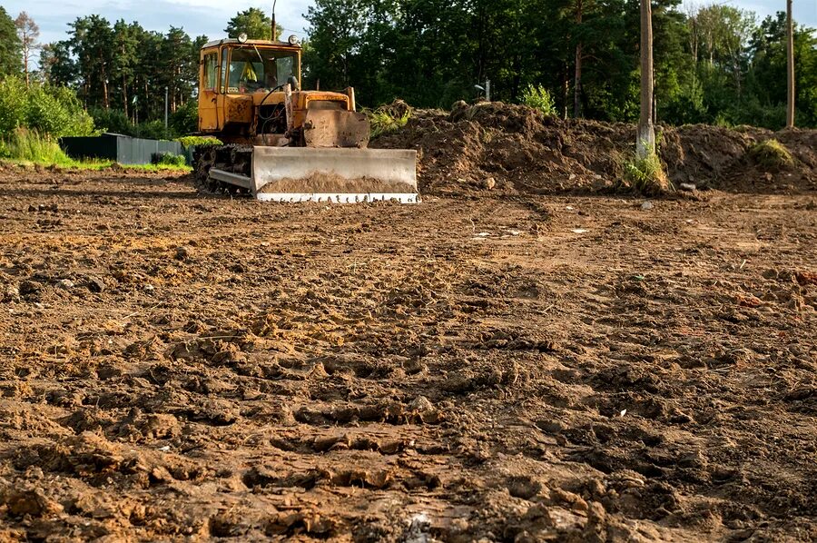 Clearing land. Расчищение почв. Cleared Land. Следы экскаватора. Человек разгружает землю.