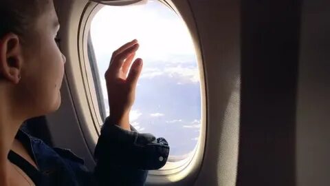 Смотрит в окно самолета