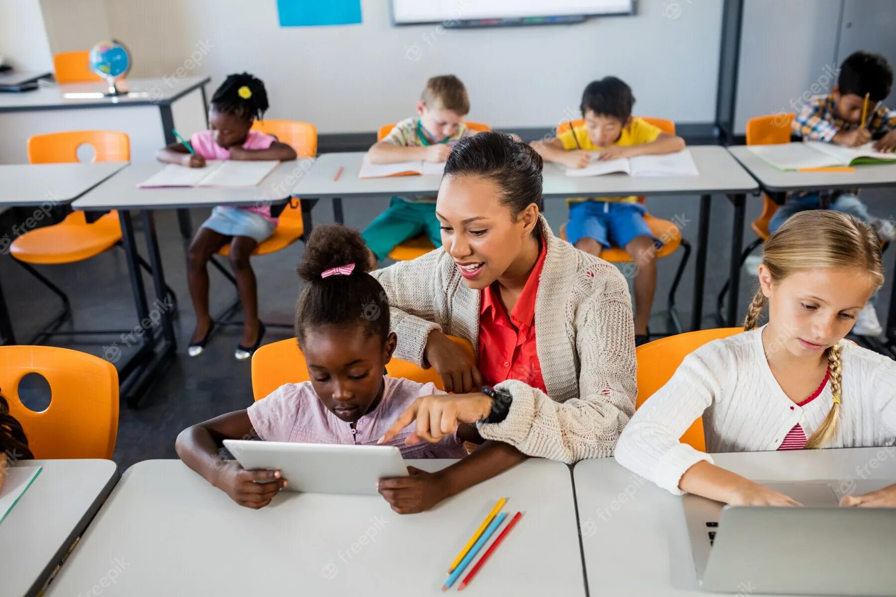 Helping in class. Письменные фото детей в школе сток. black teacher. учитель ibls. teacher enters the classroom.